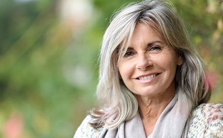 Senior woman with scarf outside and smiling