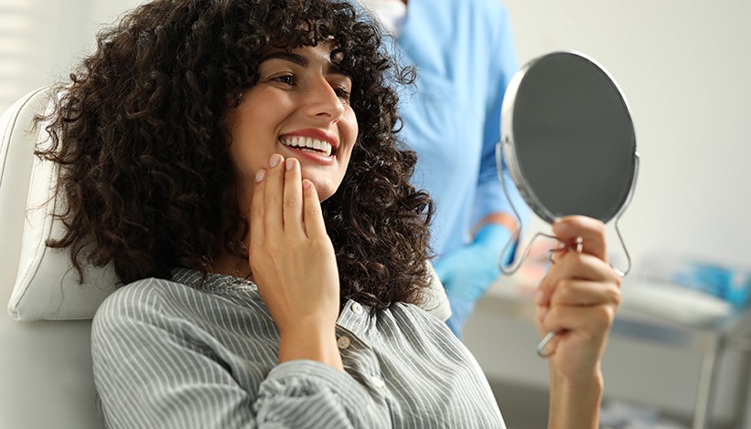 a patient admiring her new CEREC same-day crown