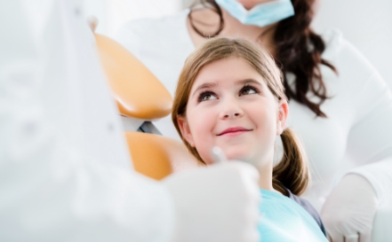 Dentist talking to young patient about dental sealants