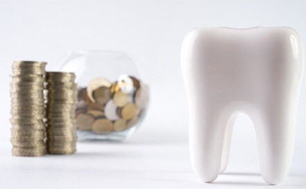 tooth next to a bowl of coins