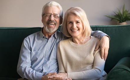 Happy older couple sitting on sofa