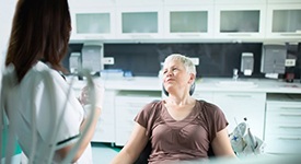 Senior woman speaking with dental team member