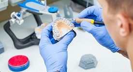 Lab technician working on wax denture model