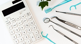 Various dental tools next to a calculator