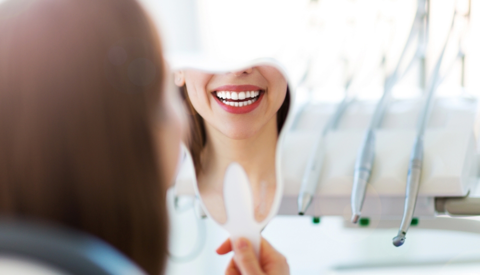 Woman looking at smile during emergency dentistry visit