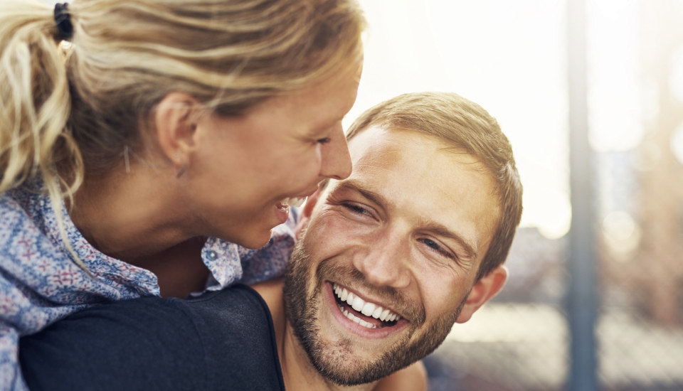 Man and woman with healthy smiles after gum disease treatment