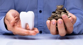 Man weighing giant tooth and coins in hands  