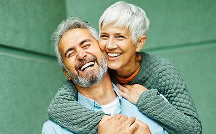 Senior man and woman smiling and laughing outside