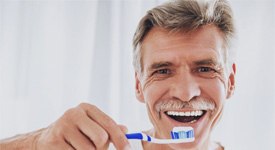woman senior man brushing his teeth   