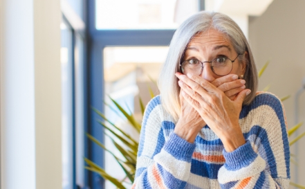 Older woman covering her mouth in fear