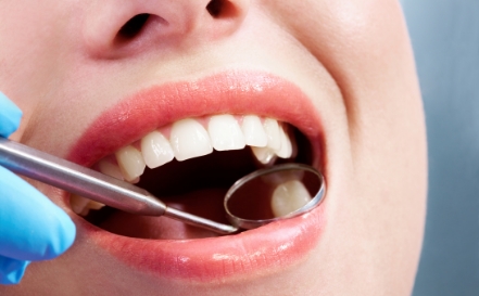 Dentist examining smile after tooth colored extractions