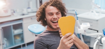 Man looking at smile druing preventive dentistry visit