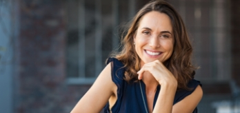 Woman smiling after replacing missing teeth