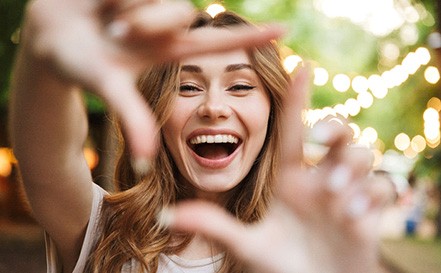 woman framing smile with hands