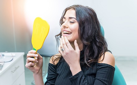 Woman looking at smile in mirror