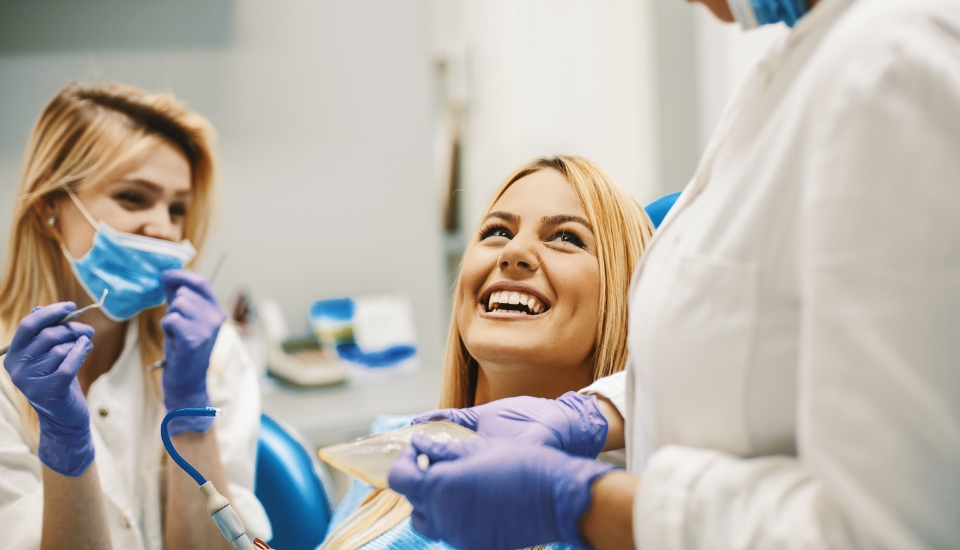 Woman smiling at dentist during wisdom tooth extraction consultation