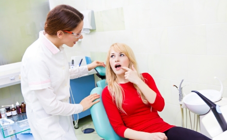 Dentist and dental patient discussing wisdom tooth extraction after care