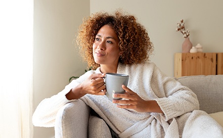 Woman relaxing on couch at home with tea